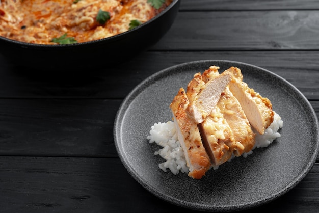 Gebakken kipfilet in roomsaus met tomaten peterselie bovenaanzicht Kipfilet op een bord gesneden kip en rijst