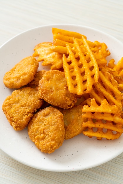 gebakken kipnuggets met gebakken aardappelen op plaat potatoes