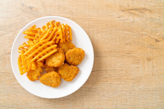 Gebakken kipnuggets met gebakken aardappelen op plaat