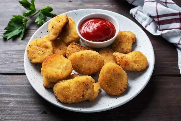 Gebakken kipnuggets met tomatenketchup saus. houten tafel. Kopieer ruimte.