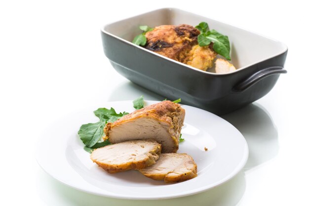 Gebakken kippenfiletstukken met specerijen en kruiden in keramische vorm