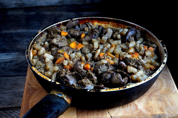 Gebakken kippenlever in een pan in de huiskeuken.