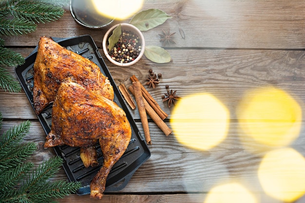 Gebakken kippenpoten in kruiden in een grillpan, op een houten ondergrond. kerstdiner