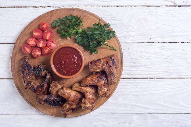 Gebakken kippenvleugels met tomatensaus en peterselie.