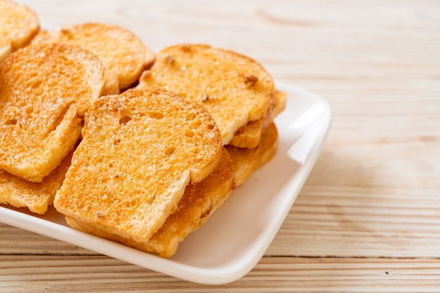 Foto gebakken knapperig brood met boter en suiker op plaat