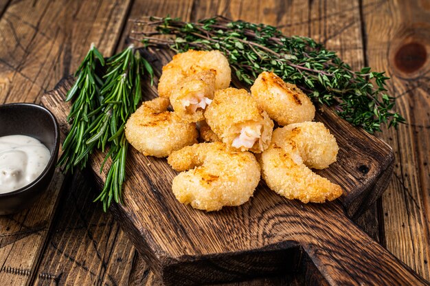 Gebakken knapperige garnalen Garnalen op een houten bord met saus