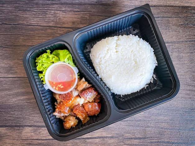 Gebakken krokant varkensvlees met jasmijnrijst in de voedselcontainer