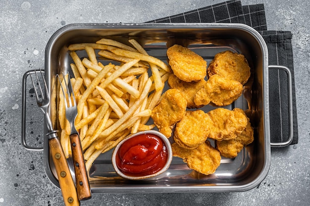 Gebakken krokante kipnuggets met ketchup en frietjes Grijze achtergrond Bovenaanzicht