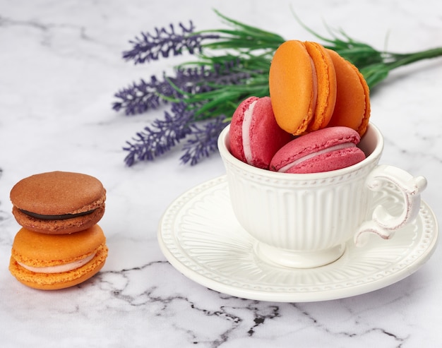 Gebakken macarons in een witte ceramische kop op tafel