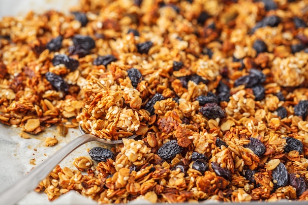 Foto gebakken muesli met rozijnen op bakplaat.