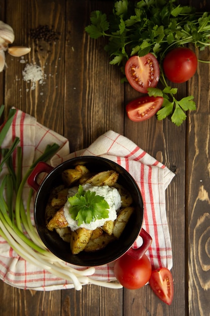 gebakken nieuwe aardappelen met saus en greens met haringtomaat en groene ui