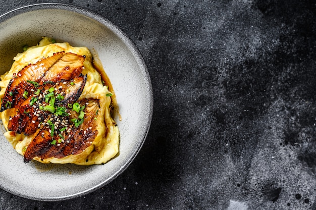 Gebakken paling met Japanse omelet en rijst. Zwarte achtergrond. Bovenaanzicht. Kopieer ruimte