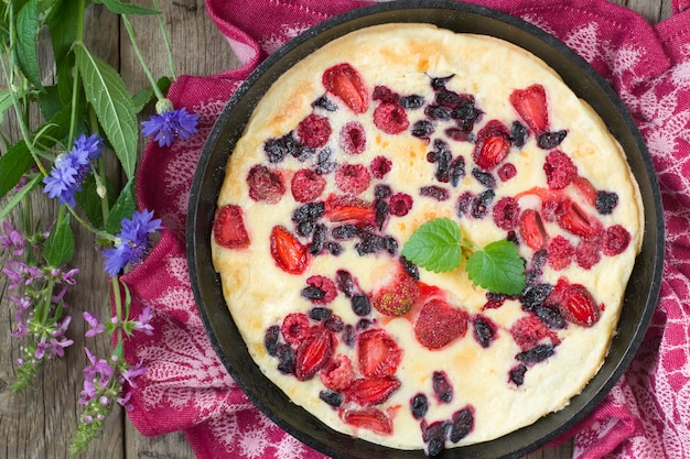 Gebakken pannekoek in ijzeren pan met verse aardbeien