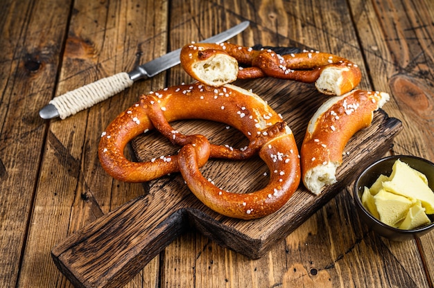 Gebakken pretzels met zeezout op een rustieke houten snijplank. Houten achtergrond. Bovenaanzicht.