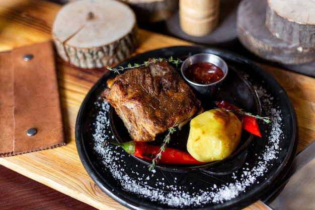 Gebakken ribbetjes met aardappelen, rode paprika en saus