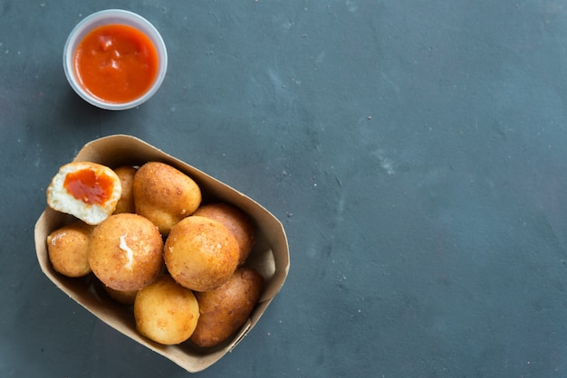 Gebakken Risotto Arancini gevuld met kaas, geserveerd met tomatensaus