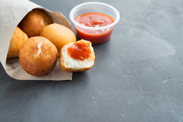 Gebakken risotto arancini gevuld met kaas, geserveerd met tomatensaus