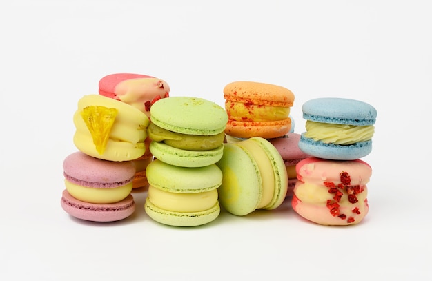 Gebakken rode macarons en rode rosebuds op een witte achtergrond, gastronomisch amandelmeeldessert