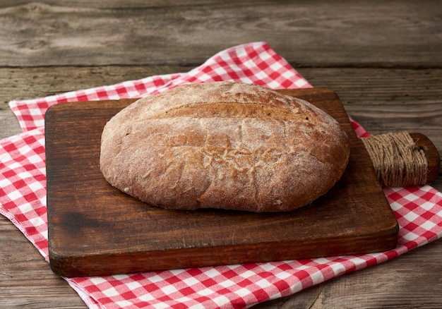 Gebakken ronde roggebloem brood op een keuken snijplank