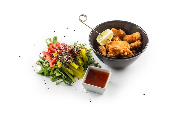 Gebakken samon stukken met saus en groente salade geïsoleerd op een witte achtergrond.