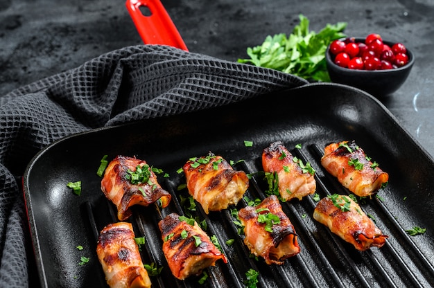 Gebakken spek gewikkeld kipfilet in een pan.