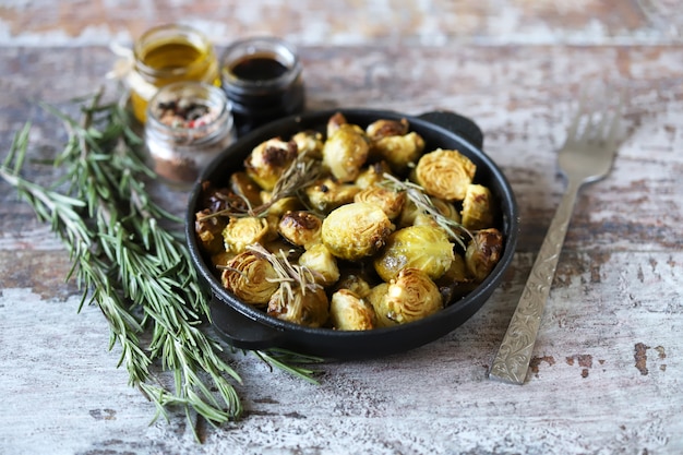 Gebakken spruitjes met rozemarijn in een pan. Vega eten. Gezond eten.