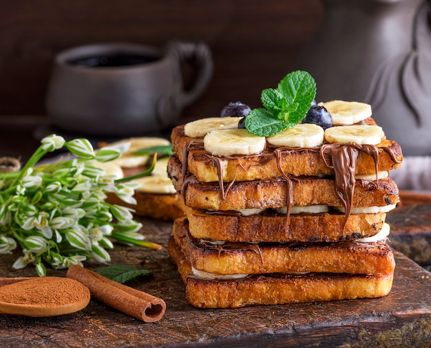 Gebakken stukjes wit brood in een ei met melk en besmeurd met chocolade, wentelteefjes