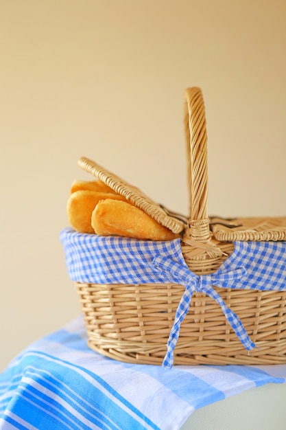 Gebakken taarten in een rieten mand op een blauw gestreept servet op beige