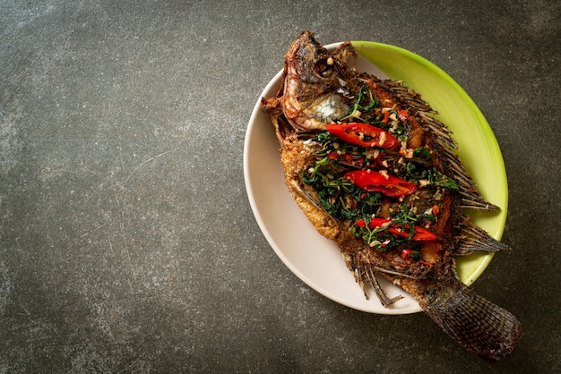 Gebakken Tilapia-vis met basilicum-chili-knoflooksaus erop - zelfgemaakte voedselstijl