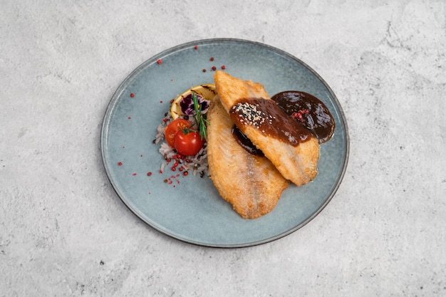 Gebakken tilapia vis met rijstsaus en groente