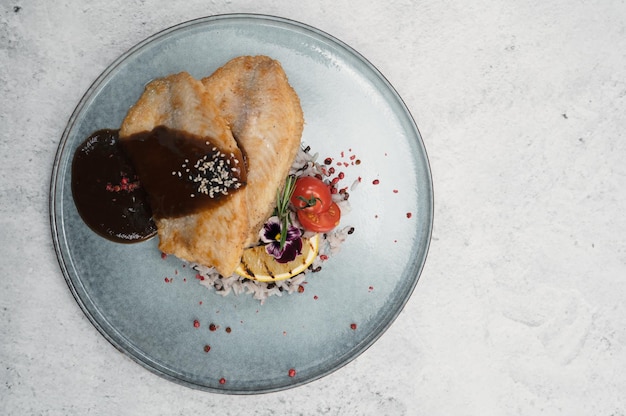 Gebakken tilapia vis met rijstsaus en groente