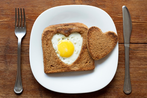 Gebakken toast met ei geserveerd op een wit bord