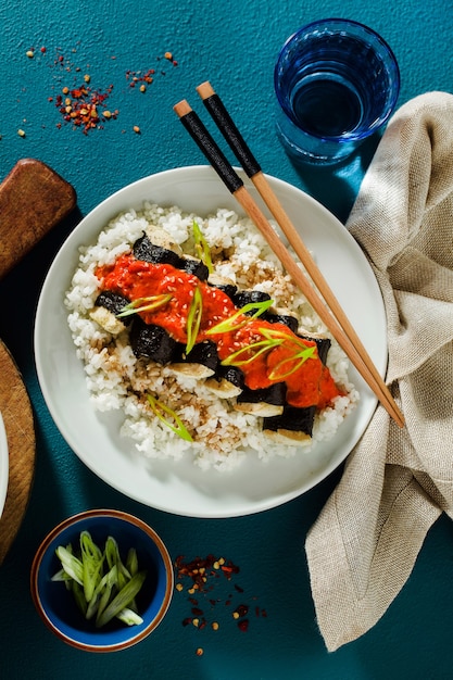 Gebakken tofu gewikkeld in nori met tomaten-kokossaus en rijst voor sushi. veganistische moderne keuken