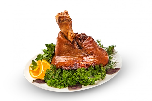 Gebakken varkensvlees, hele poot, een enorme portie met een krokante smakelijke korst op een witte tafel. geïsoleerd