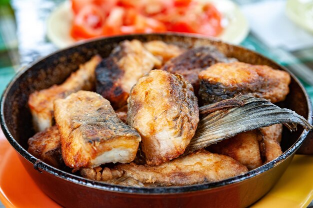 Foto gebakken vis in een pan op tafel street food fastfood concept