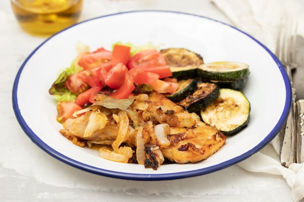 Foto gebakken vlees met courgette en frisse salade op het bord