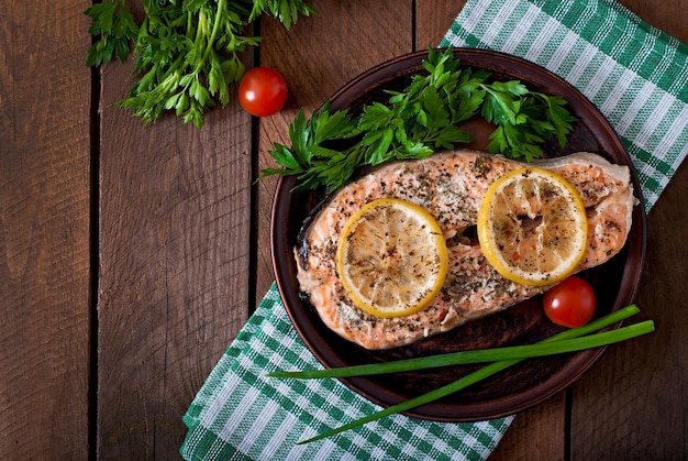 Gebakken zalmsteak met kruiden, citroen en salade.