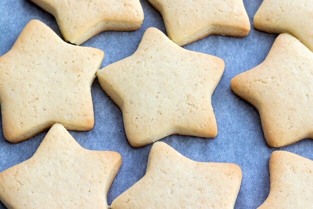 Gebakken zandkoekjes in de vorm van sterren op een bakplaat