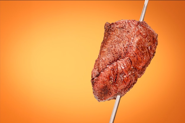 Gebarbecued picanha barbecue met oranje achtergrond ook wel churrasco . genoemd