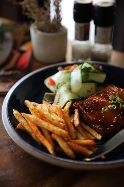 Gebarbecued varkensribstuk met verse groenten op een oude rustieke houten in restaurant