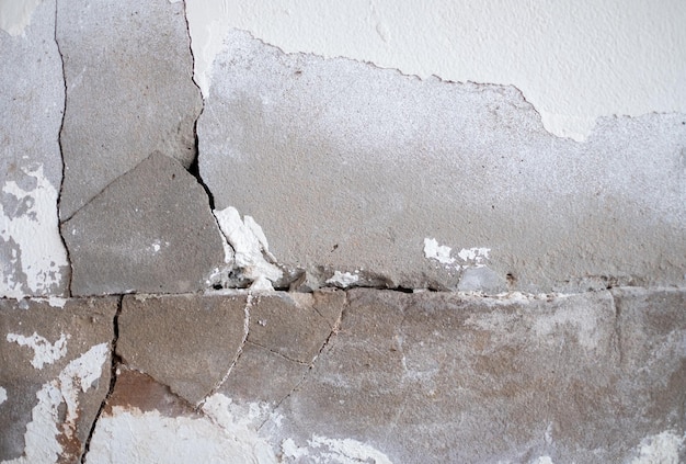 Gebarsten betonnen muur gebroken muur aan de buitenste cementhoek die veroorzaakt werd door aardbeving en ingestorte grond