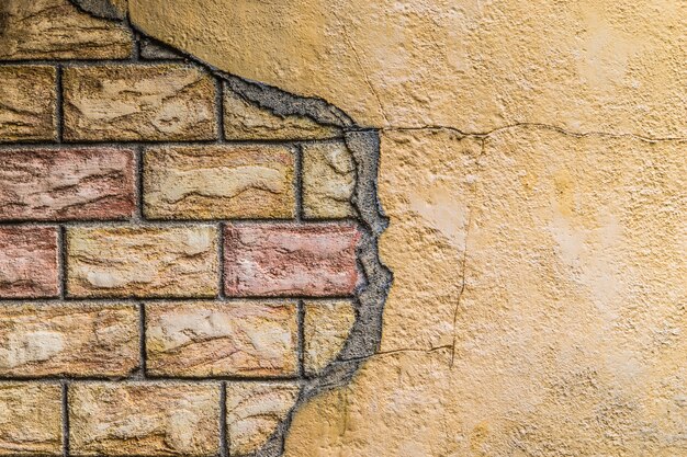 Foto gebarsten concrete muur met rode baksteentextuur