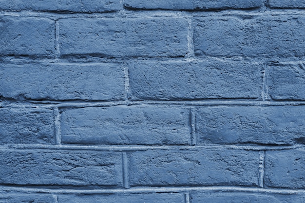 Gebarsten en getextureerde blauwe muur, bakstenen muur achtergrond. Kleur van het concept van het jaar 2020.