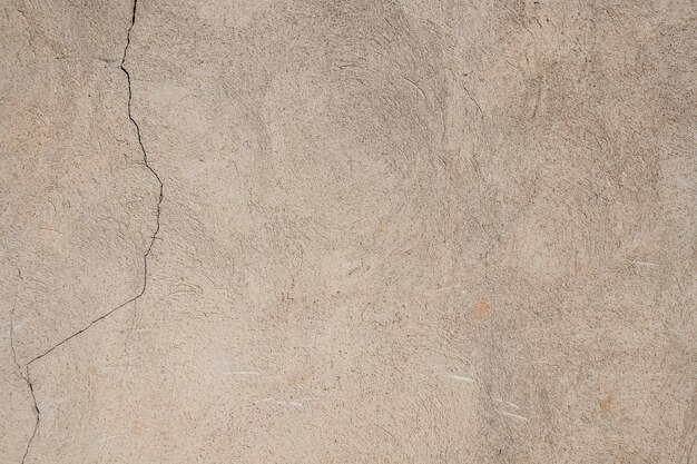 Gebarsten gepleisterde cementmuur als achtergrondclose-up