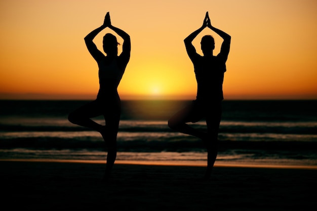 Gebedshanden yoga silhouet en meditatie met paar op het strand voor gezondheid of welzijn Zonsondergang pilates schaduw en man en vrouw met namaste hand pose voor training zen chakra of evenwichtsoefening