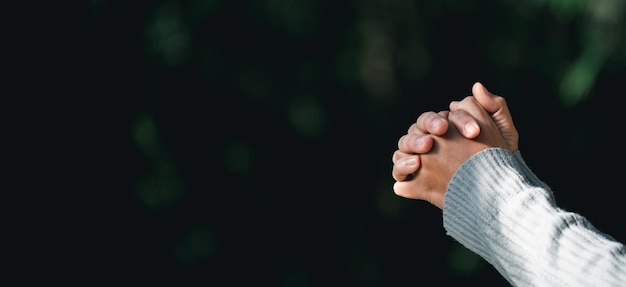 Foto gebedspersoon hand op zwarte achtergrond christelijke katholieke vrouw bidt tot god in het donker in de kerk meisje gelooft en geloof in jezus christus christus religie en christendom aanbidding of bid concept