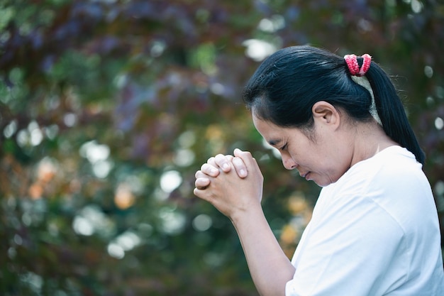 Gebedspersoon hand op zwarte achtergrond christelijke katholieke vrouw bidt tot god in het donker in de kerk meisje gelooft en geloof in jezus christus christus religie en christendom aanbidding of bid concept