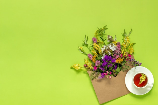 Gebiedsbloemen in ambachtenvelop en kop van kruidenthee