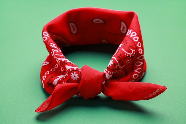 Gebonden rode bandana met Paisley-patroon op lichtgroene close-up als achtergrond