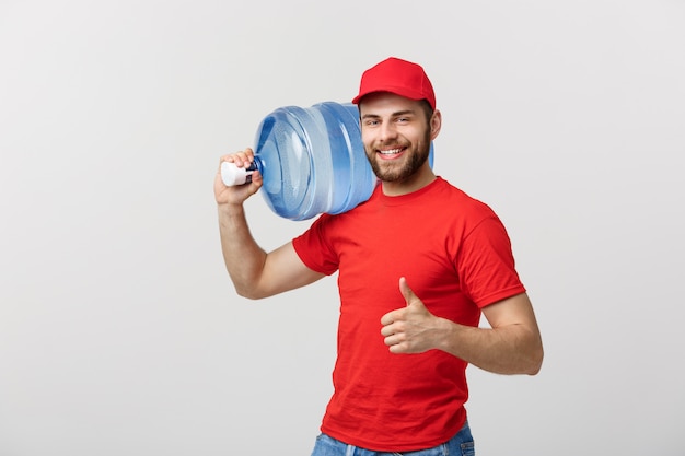 Gebotteld water levering koerier in rood t-shirt en pet dragende tank drinken en tonen t